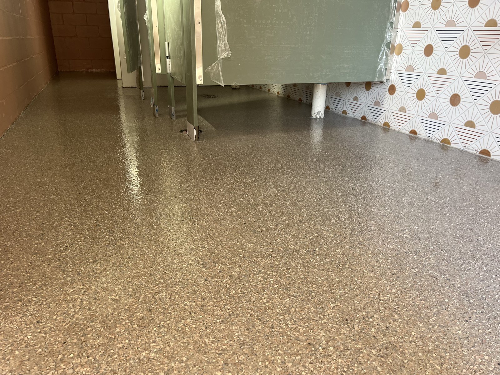 Public restroom with tan decorative flake floor, suitable for school locker rooms and restrooms