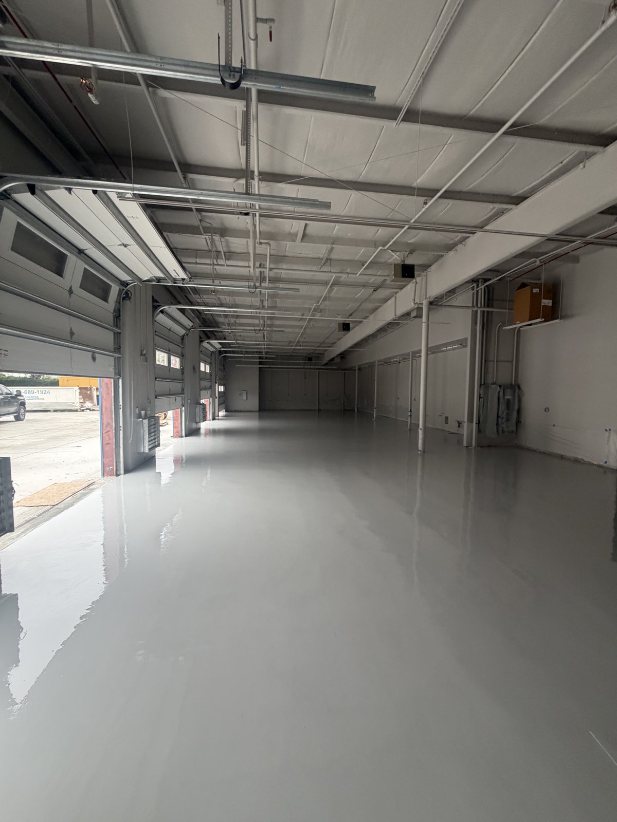 Garage bay with freshly poured gray epoxy coating